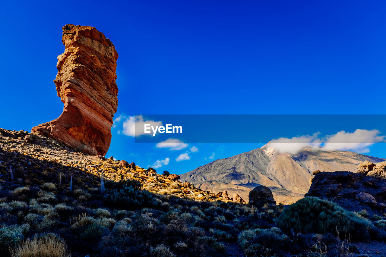 low angle view of rock formations against clear blue sky