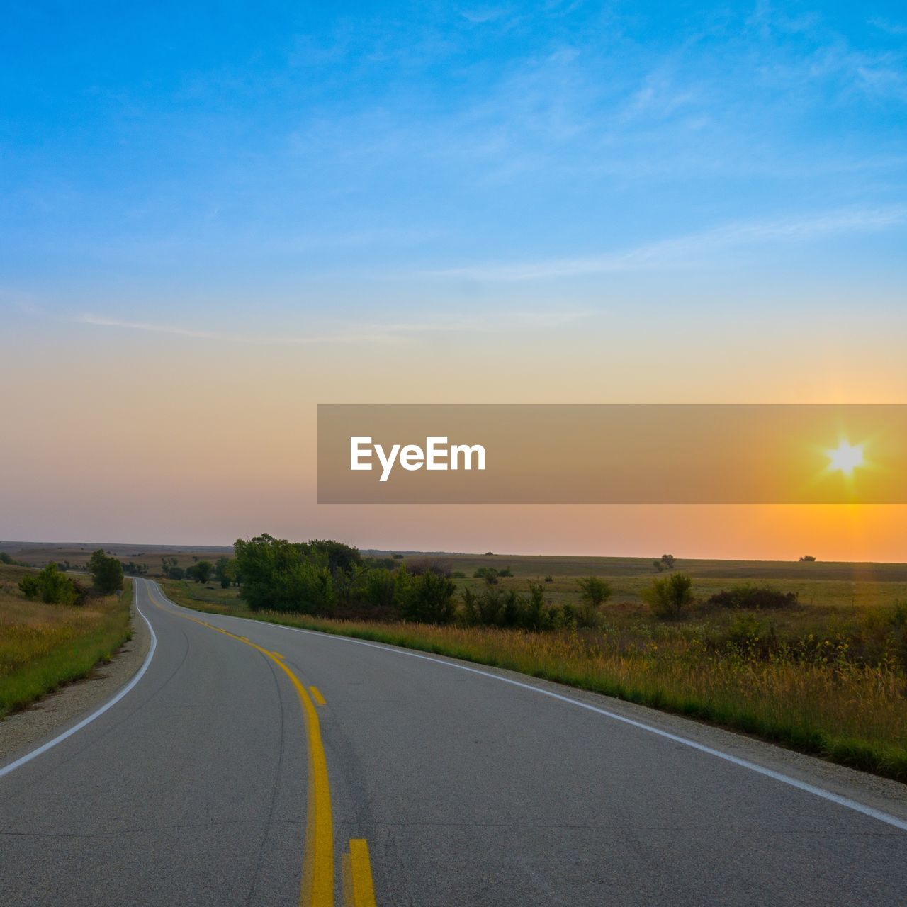 Road amidst landscape against sky during sunset