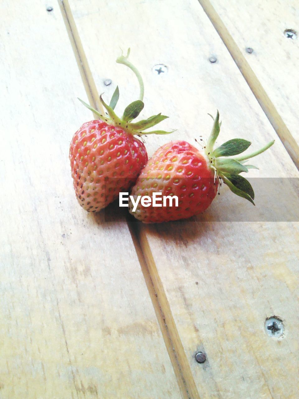 High angle view of strawberries on wooden plank