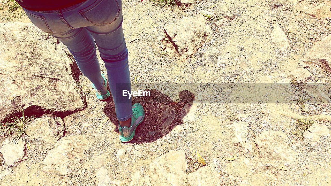 LOW SECTION OF PERSON STANDING ON TILED FLOOR