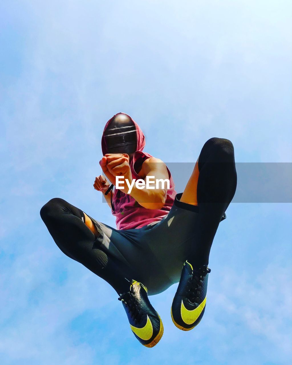 Low angle view of man jumping against sky