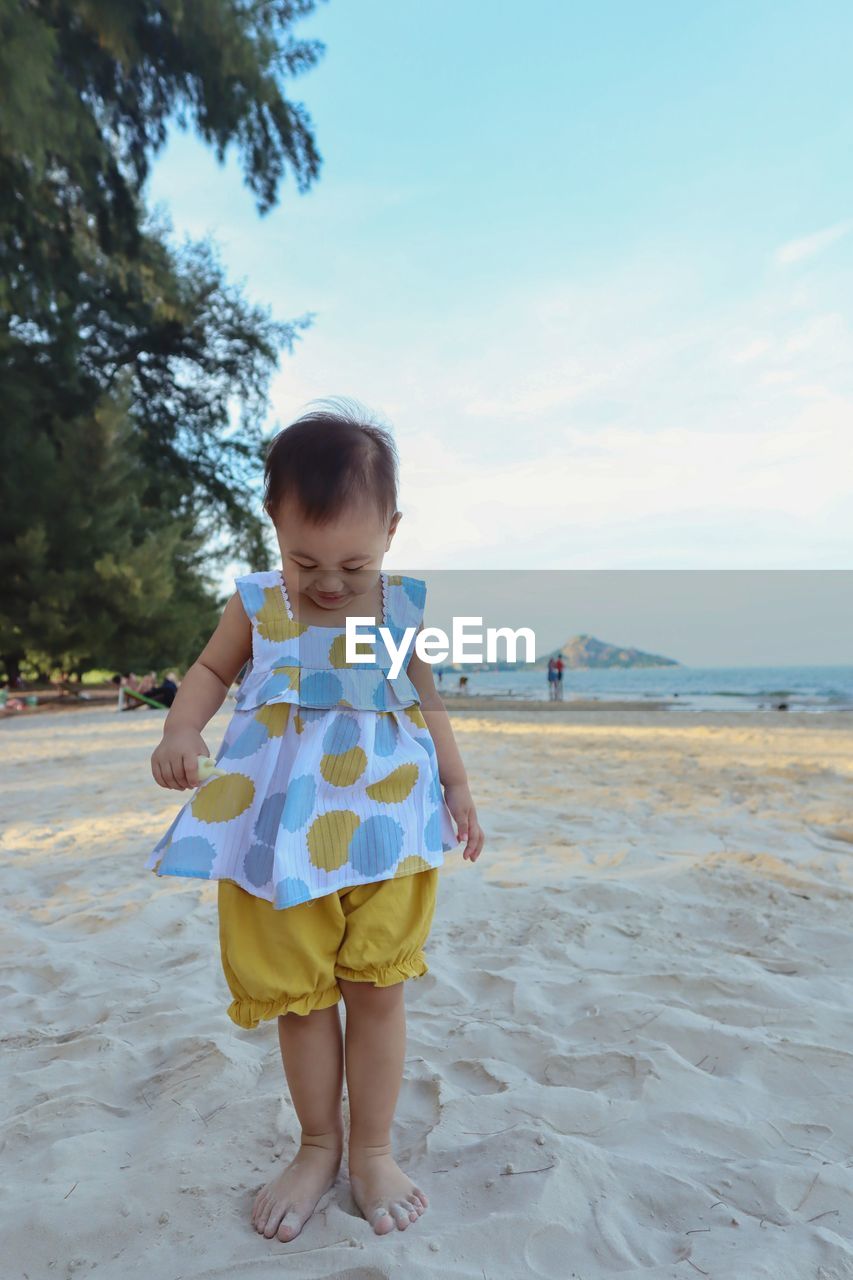 Full length of girl standing on sand at beach