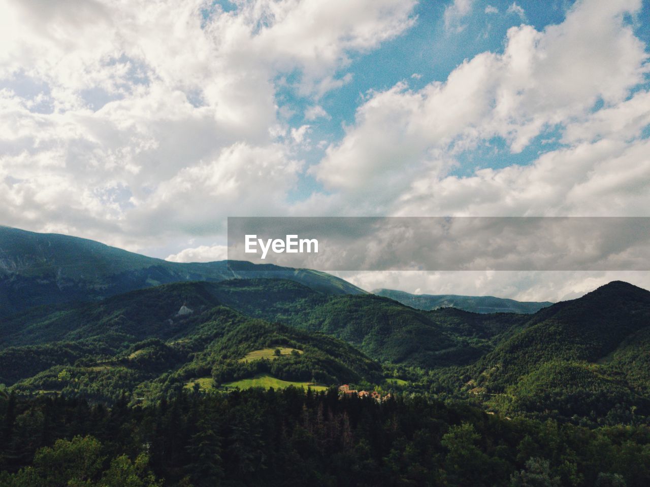 SCENIC VIEW OF TREES AND MOUNTAINS AGAINST SKY