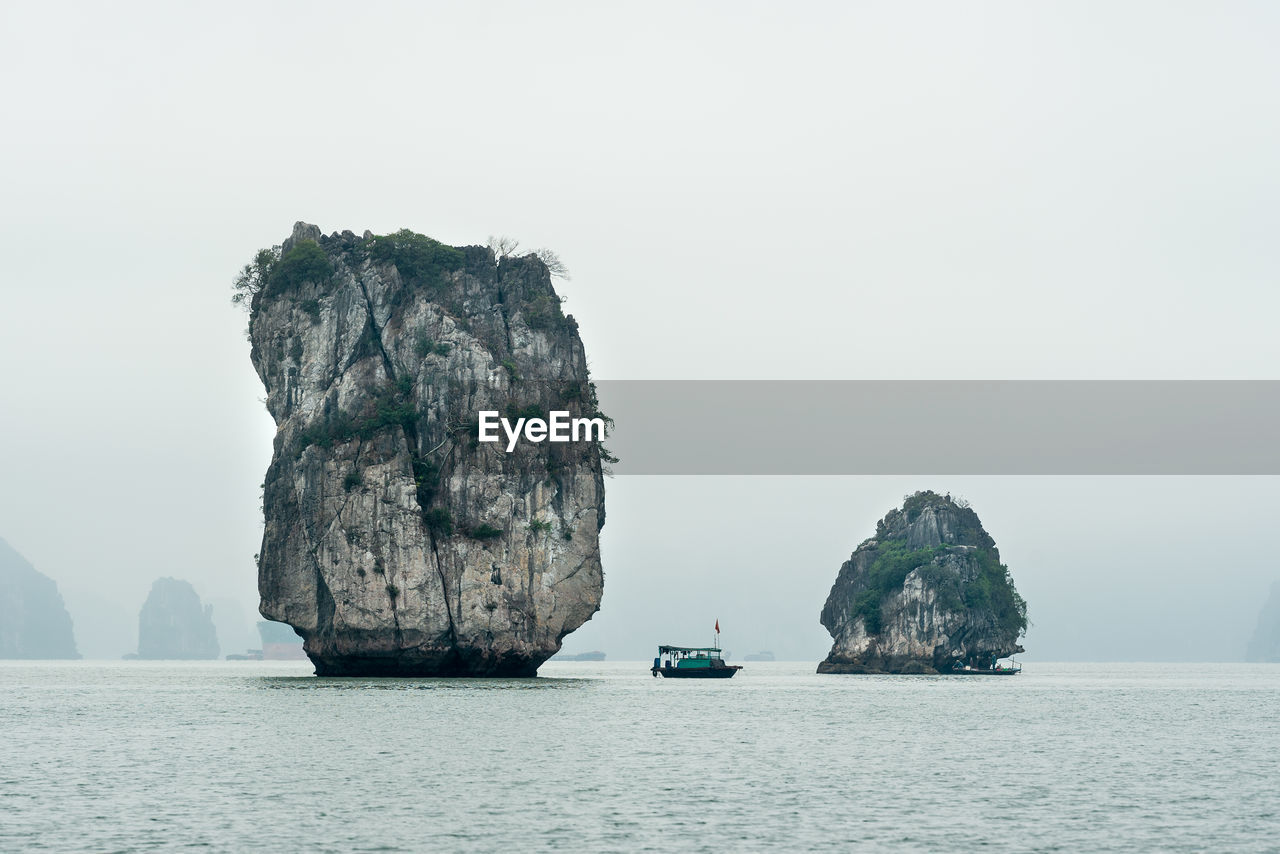 Scenic view of rock formation in sea against sky