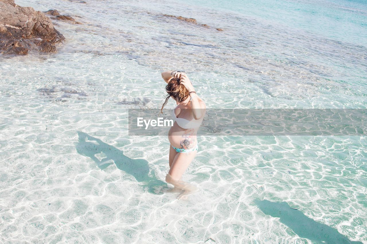 Pregnant woman wading in sea