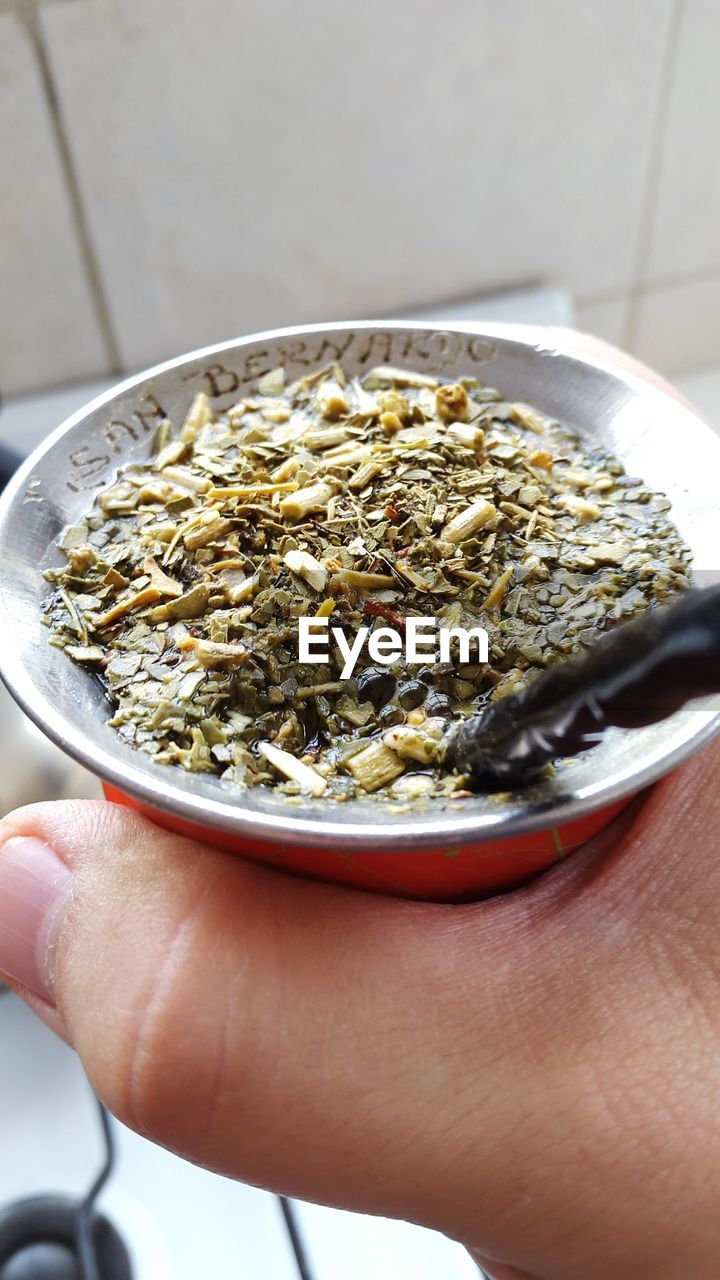 Cropped image of hand holding yerba mate at home