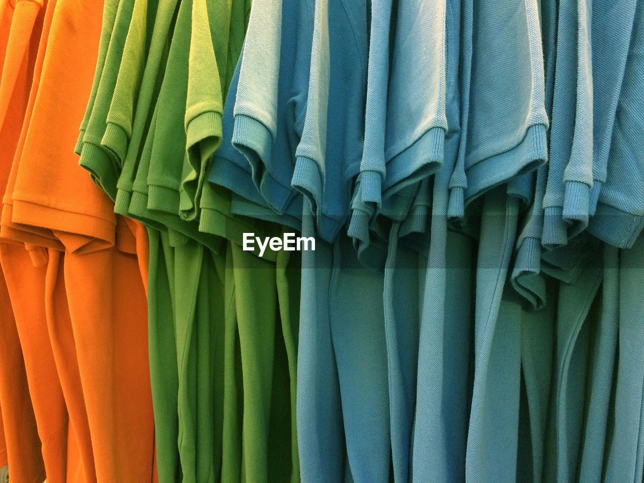 Close-up of multi colored t-shirts hanging for sale