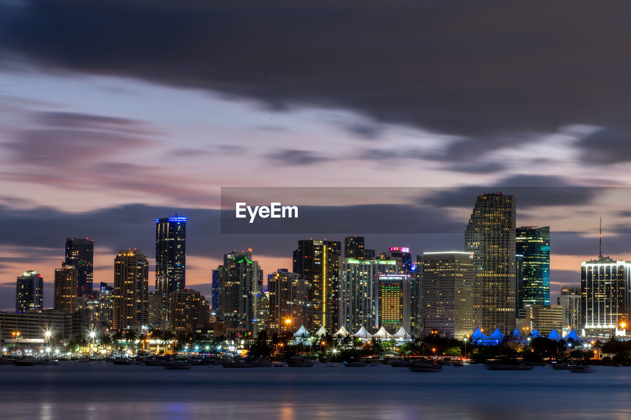 Illuminated buildings in city against sky at night