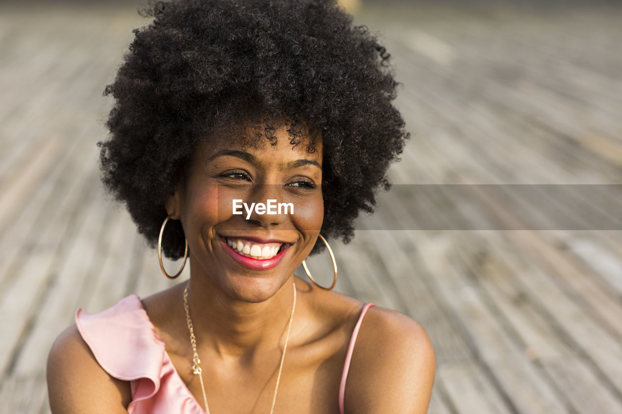 Smiling young woman sitting on boardwalk