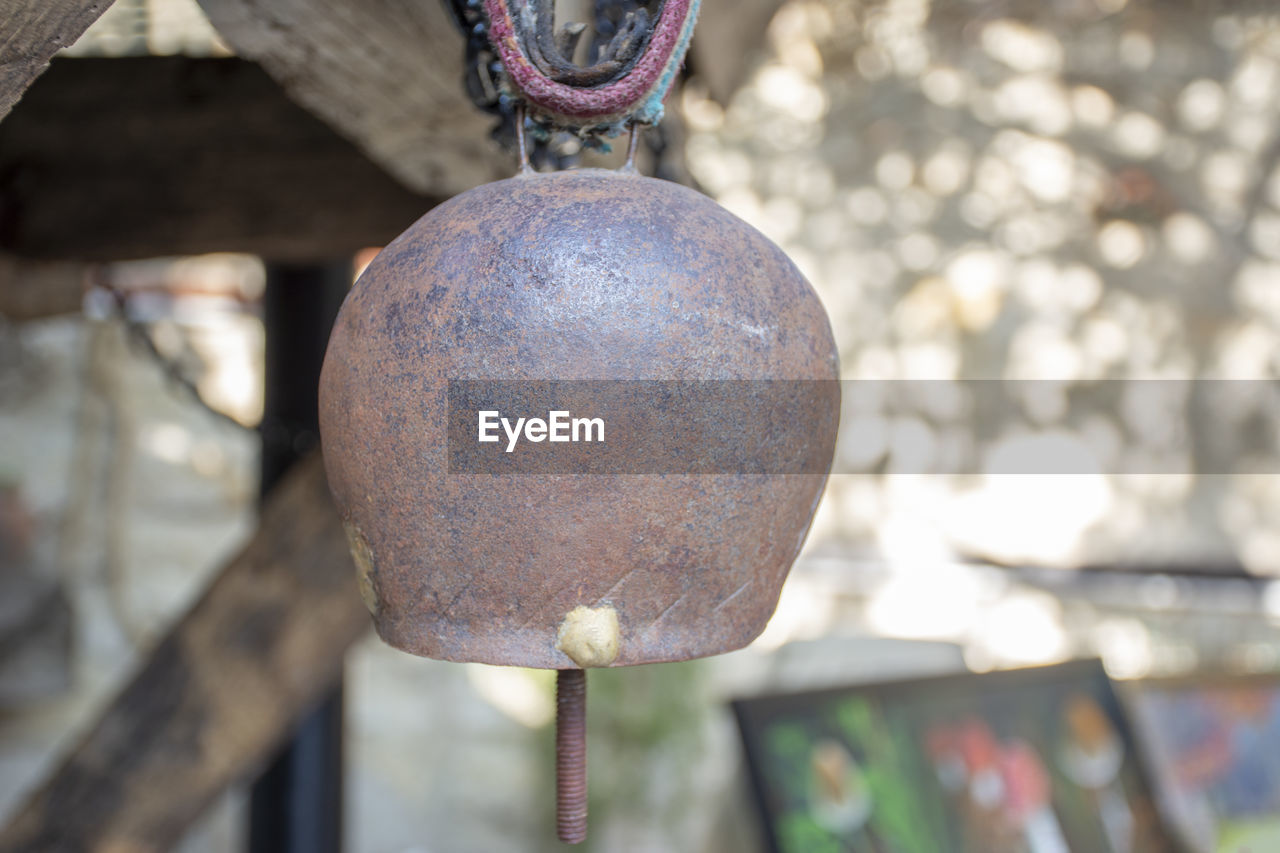 CLOSE-UP OF RUSTY METAL HANGING FROM PIPE