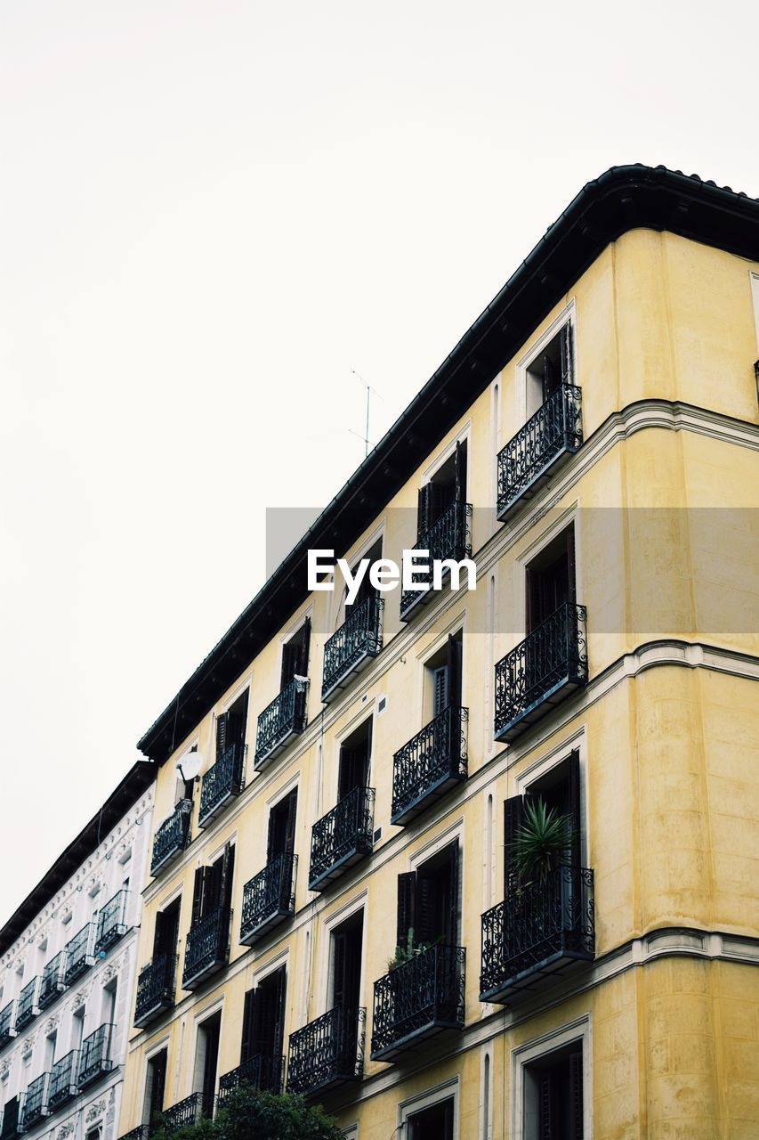 LOW ANGLE VIEW OF RESIDENTIAL BUILDING AGAINST SKY
