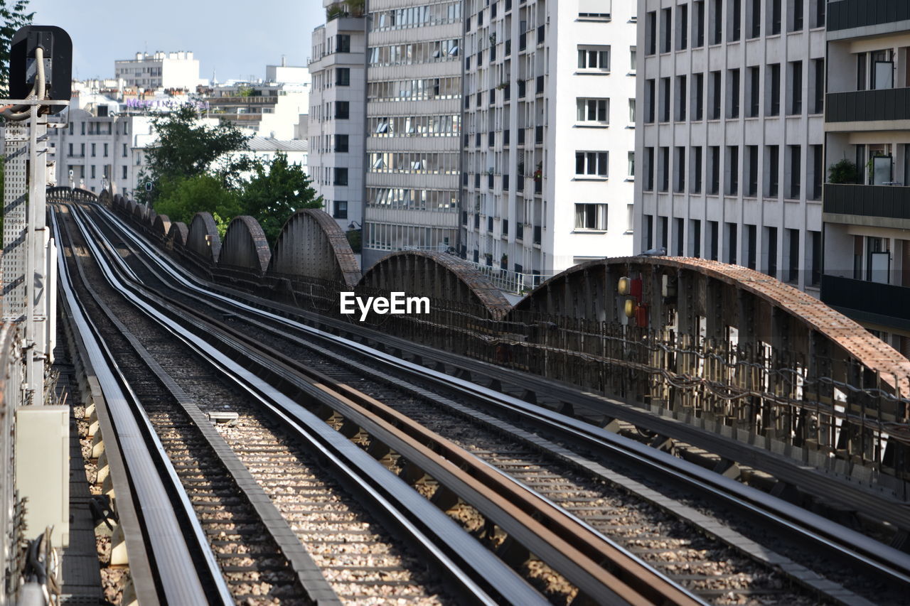 Railroad tracks amidst buildings in city