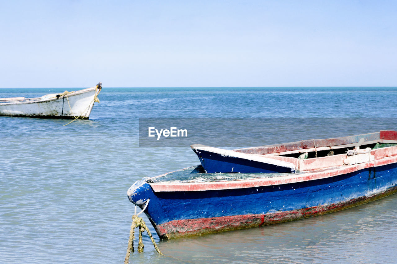 water, nautical vessel, transportation, sea, boat, mode of transportation, vehicle, long-tail boat, sky, nature, horizon over water, ship, blue, boating, watercraft, no people, beach, horizon, travel, day, tranquility, moored, scenics - nature, land, clear sky, shore, beauty in nature, outdoors, tranquil scene, bay, travel destinations, coast, ocean