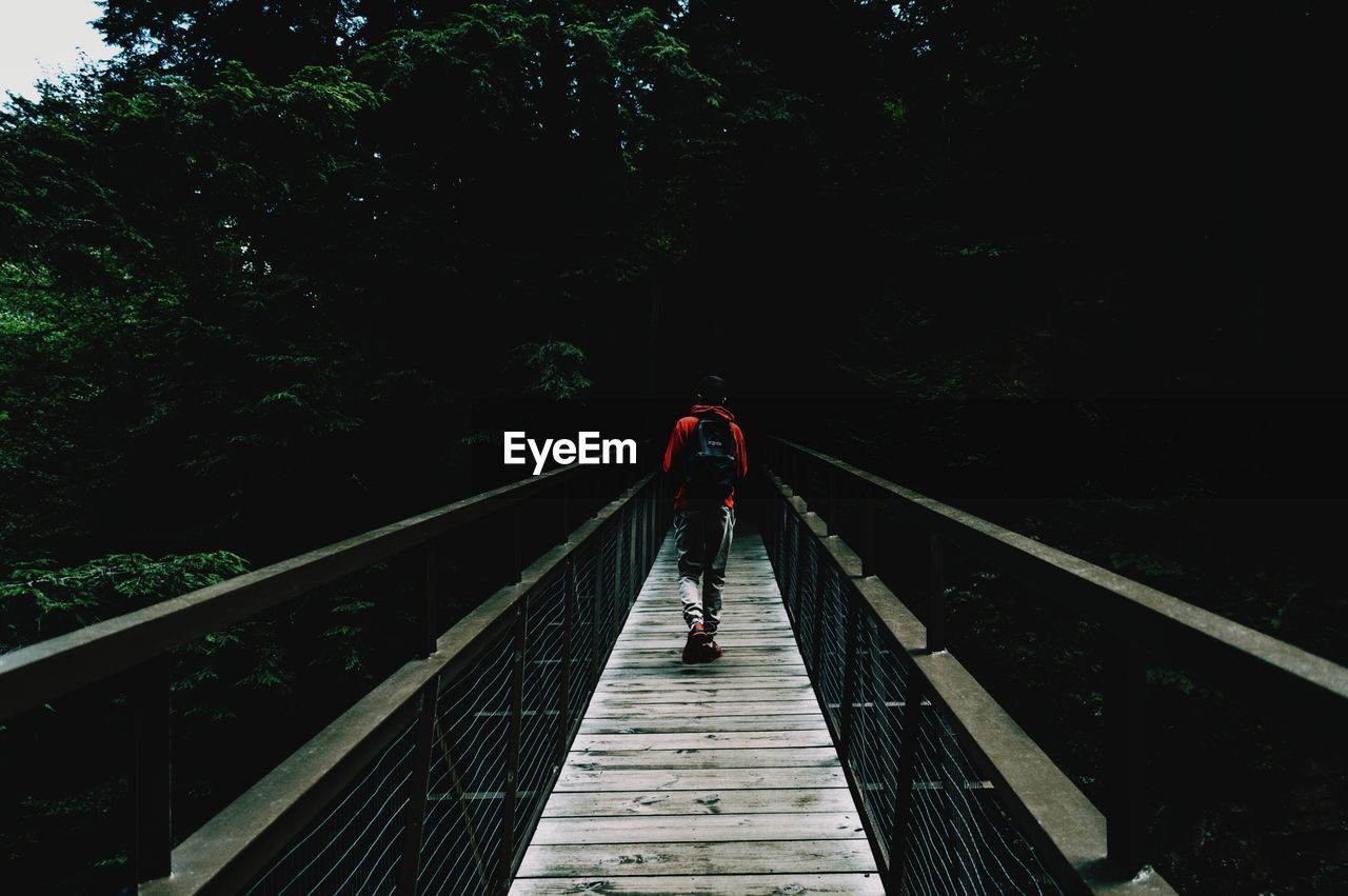 WOMAN WALKING ON FOOTBRIDGE