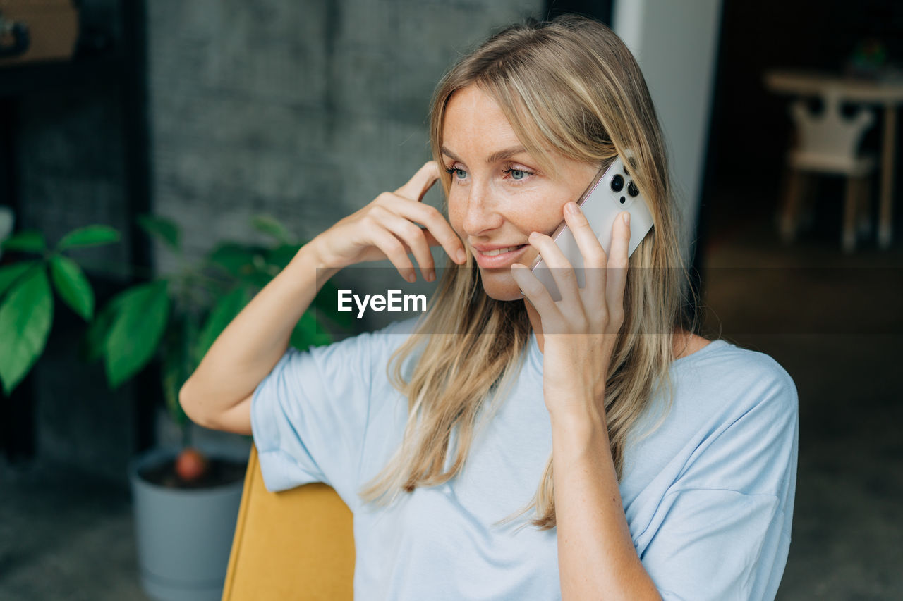 Young woman looking away and using mobile phone