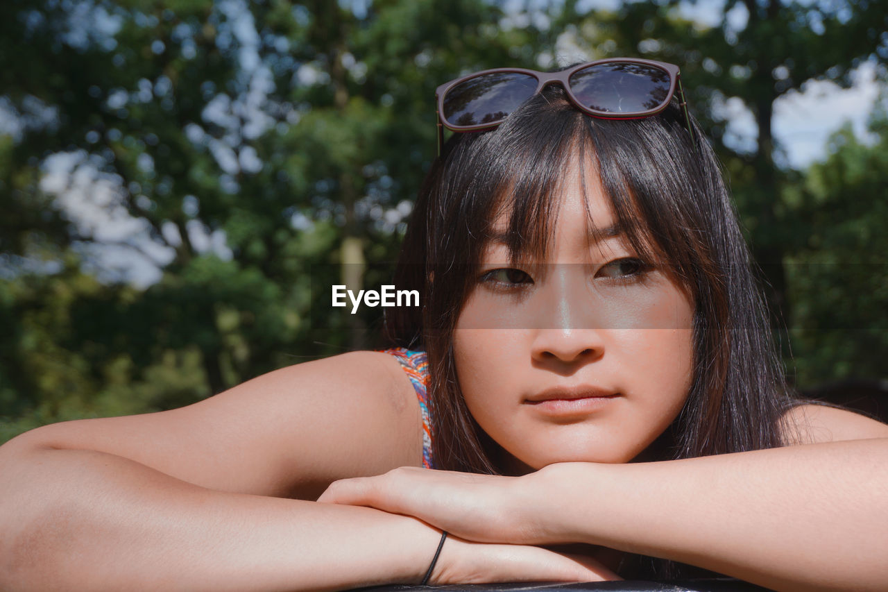 Close-up of thoughtful young woman looking away at park