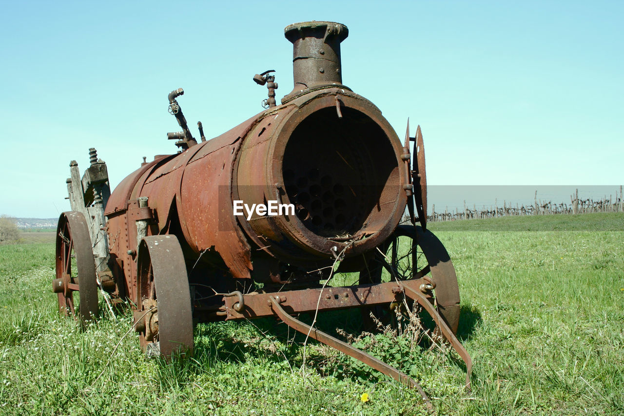 Close-up of rusty machine on grassy field