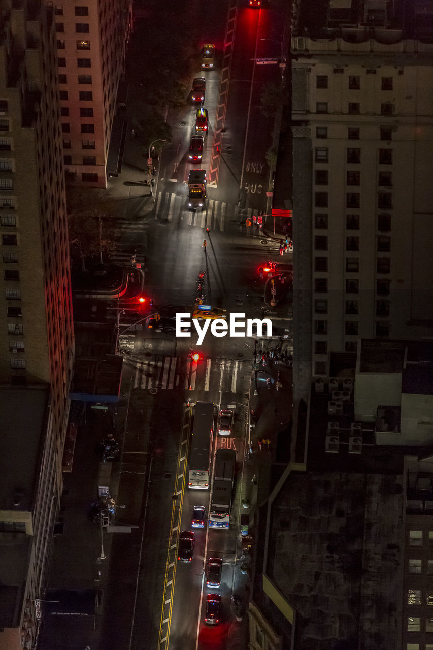 HIGH ANGLE VIEW OF TRAFFIC ON ROAD AMIDST BUILDINGS