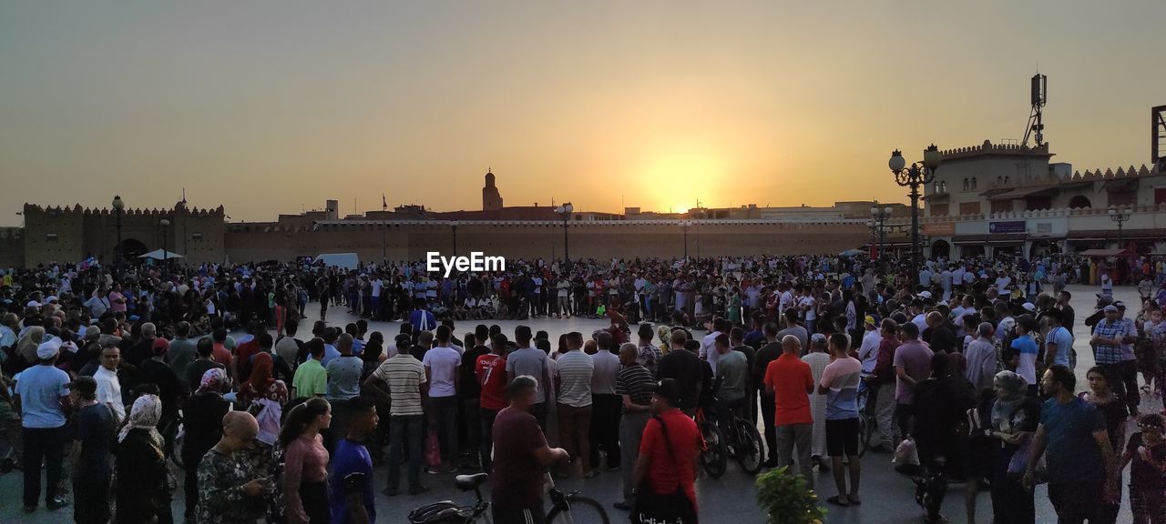crowd, large group of people, group of people, sunset, sky, architecture, person, nature, event, arts culture and entertainment, city, audience, outdoors, men, performance