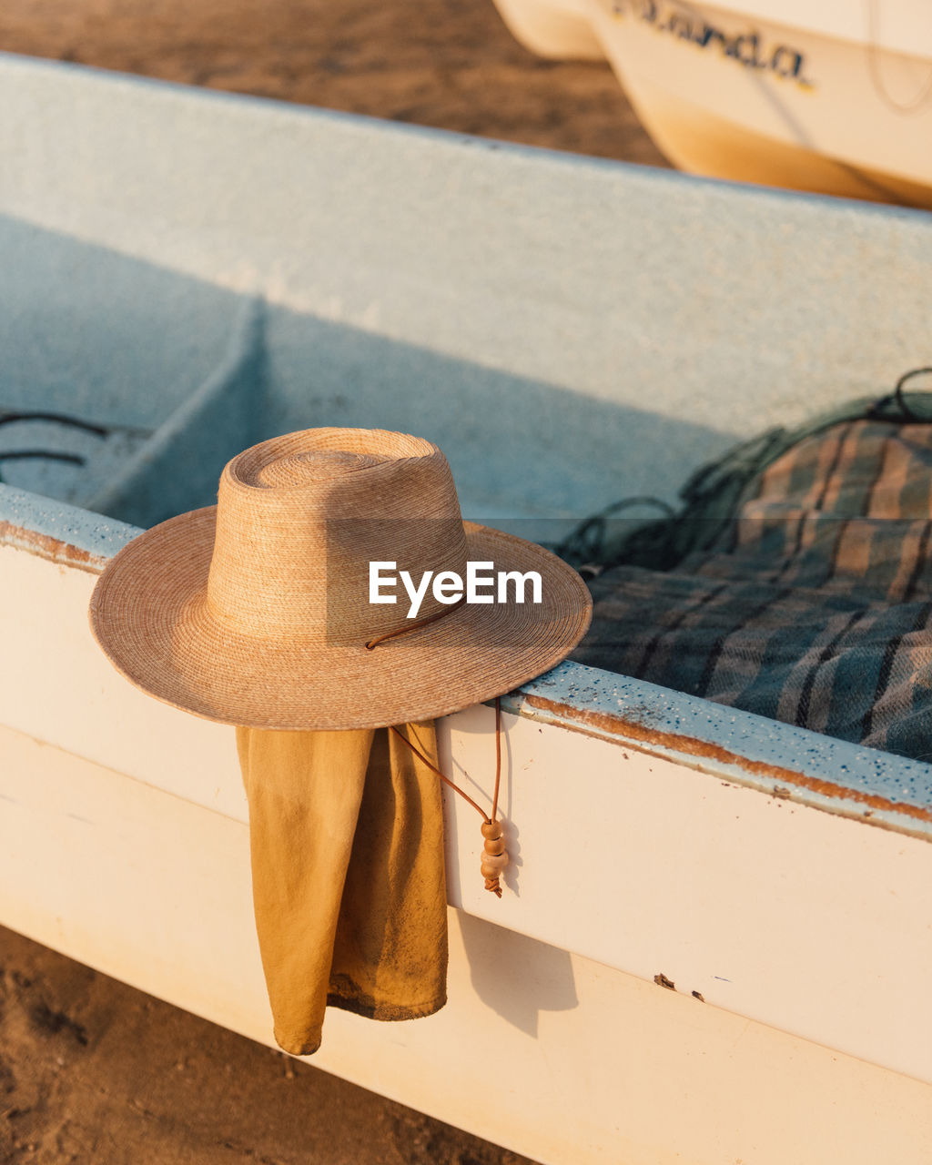 A traveller's hat rest along side a fishing boat