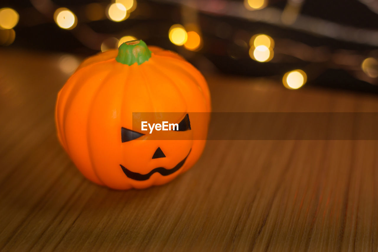 VIEW OF ILLUMINATED PUMPKIN ON ORANGE