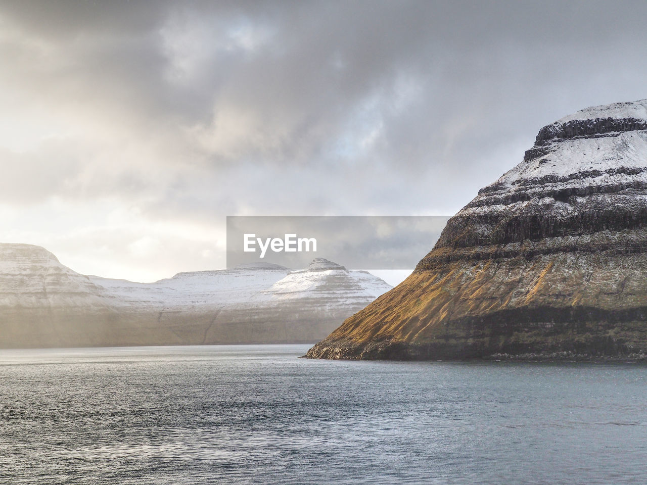 Scenic view of sea and mountains against sky