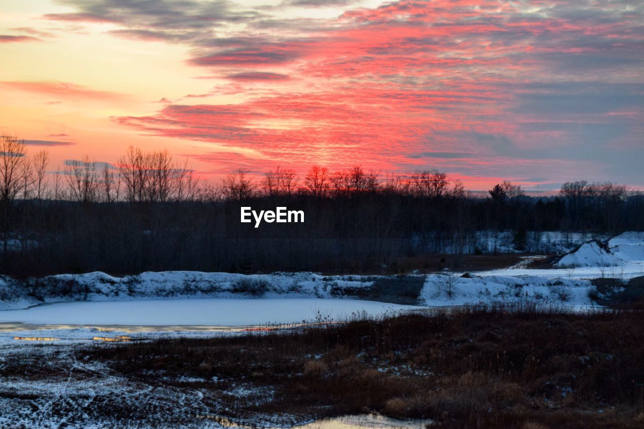 SNOW COVERED LANDSCAPE AT SUNSET