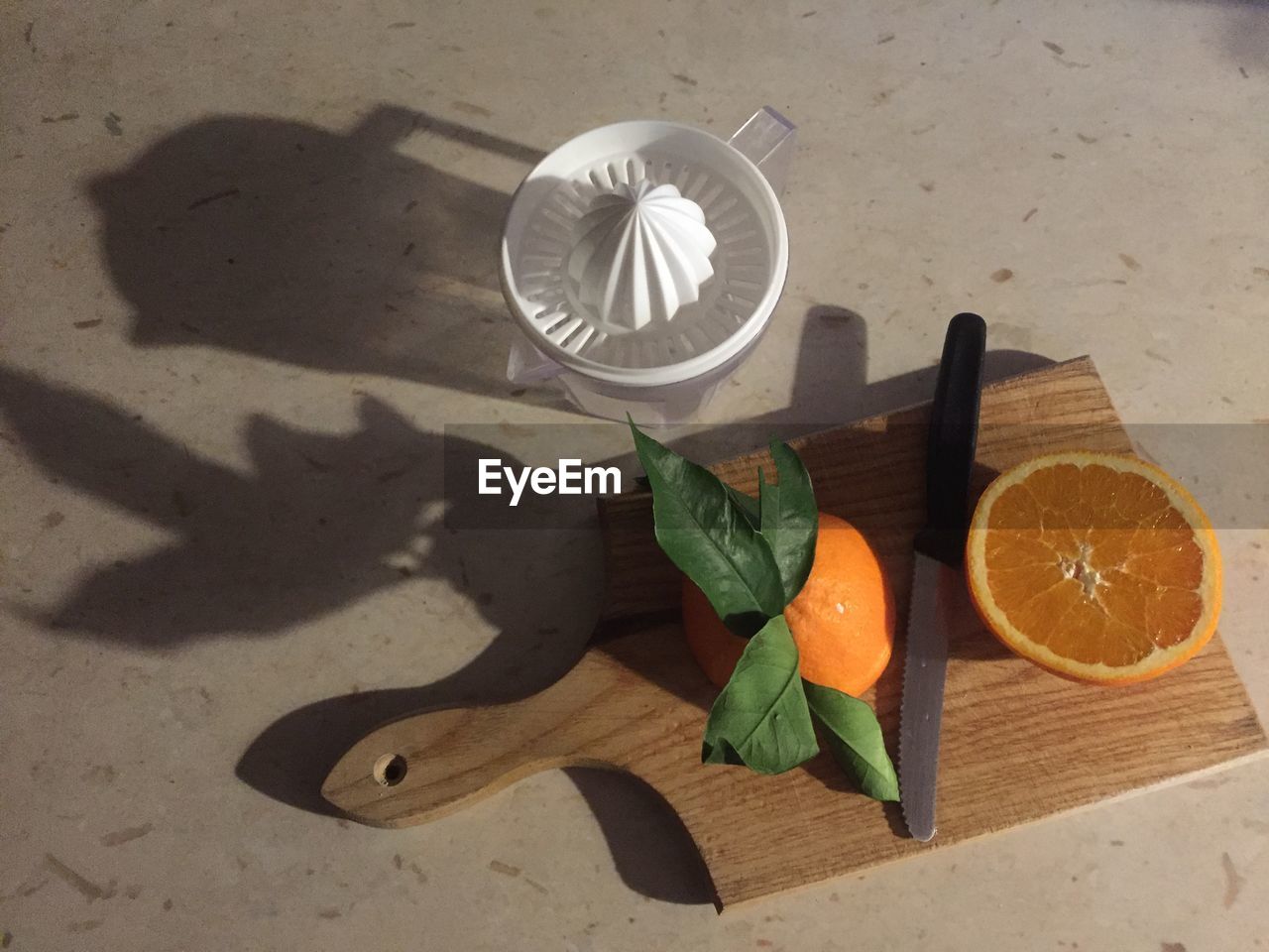 High angle view of sliced orange with cutting board and juice maker on floor