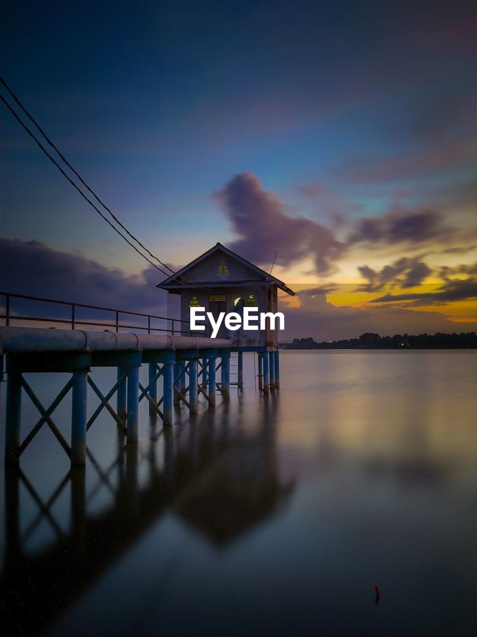 Pier over sea against sky during sunset