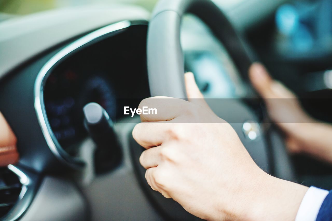 Cropped image of hands driving car