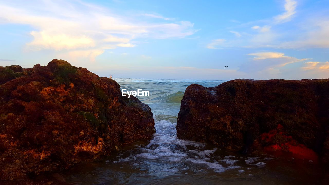 SCENIC VIEW OF SEA AND ROCKS AGAINST SKY