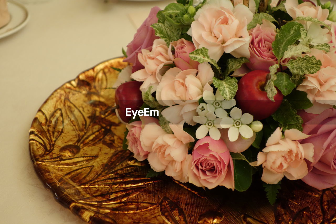 Close-up of artificial flowers in plate on table