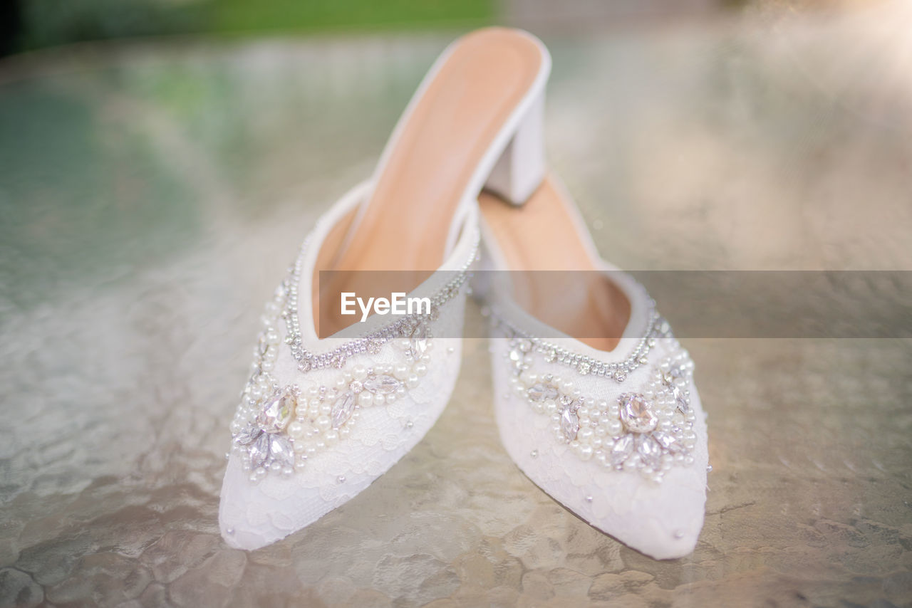 footwear, shoe, white, fashion, bridal shoe, women, high heels, wedding, spring, human leg, adult, pink, wedding dress, celebration, sandal, limb, stiletto, elegance, focus on foreground, close-up, bride, newlywed, clothing, life events, pair, event, one person, fashion accessory, outdoors, day