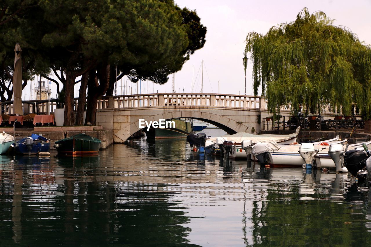 BRIDGE OVER RIVER BY TREES AGAINST SKY