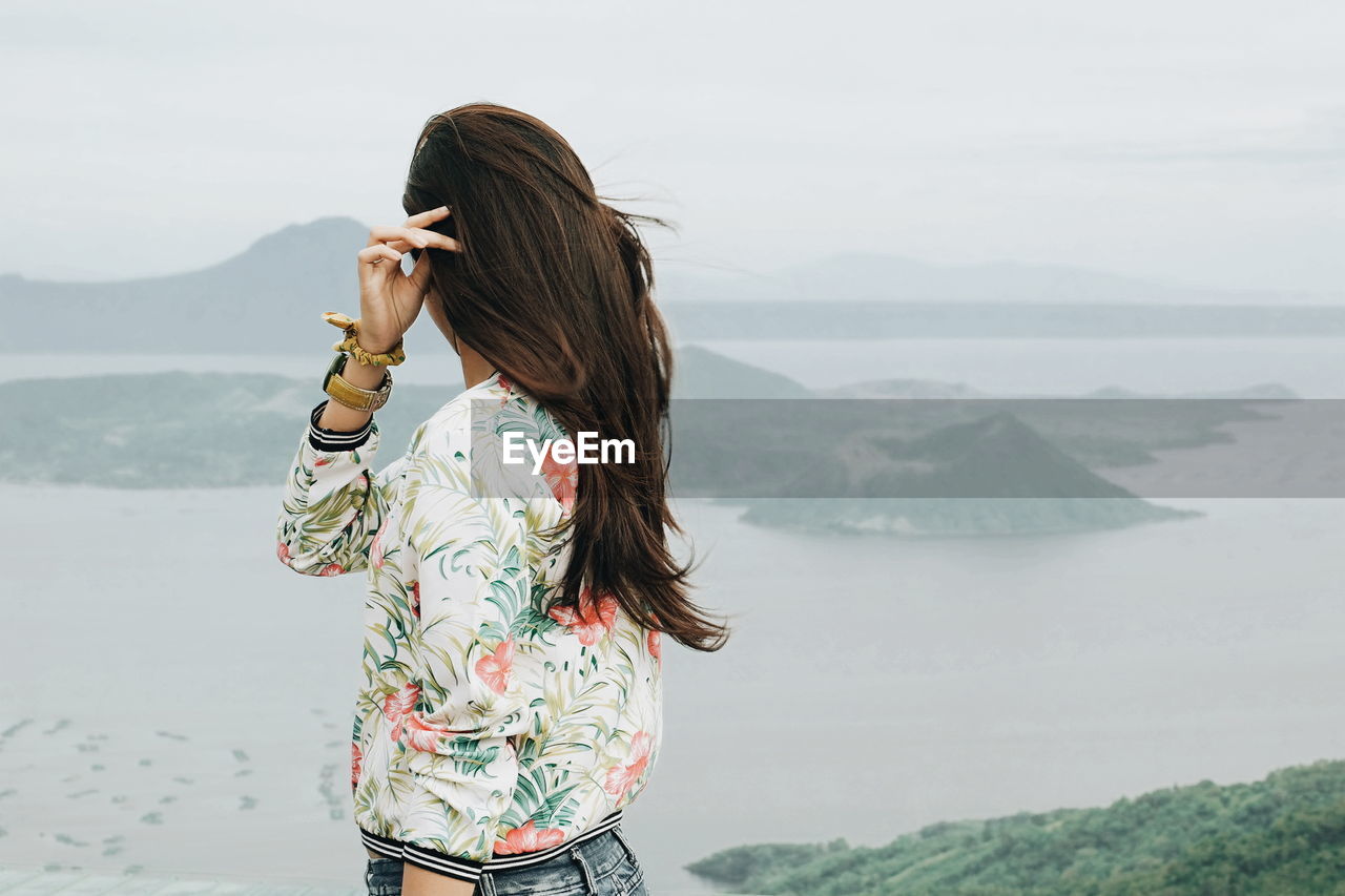 Side view of girl looking at view of taal volcano island