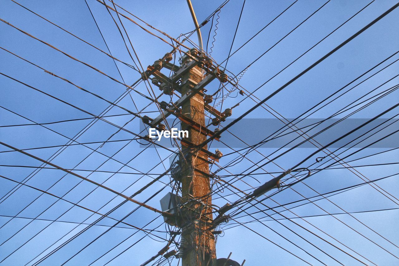 Low angle view of electricity pylon against clear sky