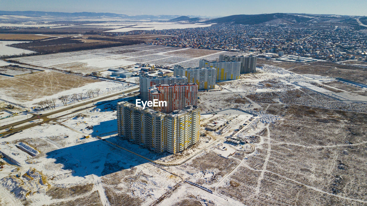 HIGH ANGLE VIEW OF BUILDINGS AGAINST CLOUDY SKY