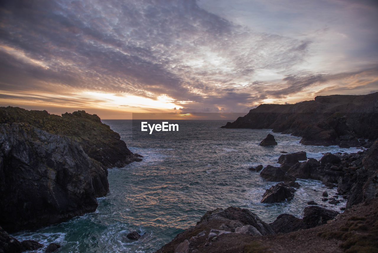 Scenic view of sea against sky during sunset at kynance cove