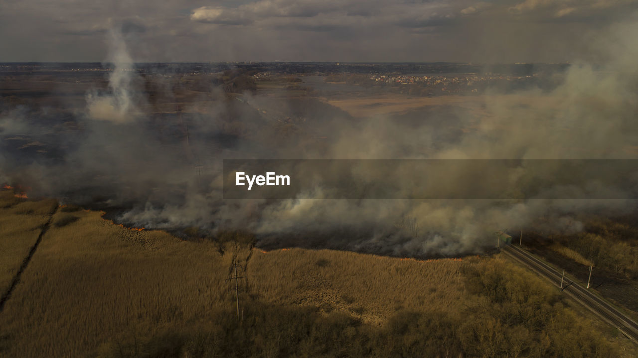 Massive fire, dry grass lanes in fire, firefighters at work, disaster, ecological catastrophe