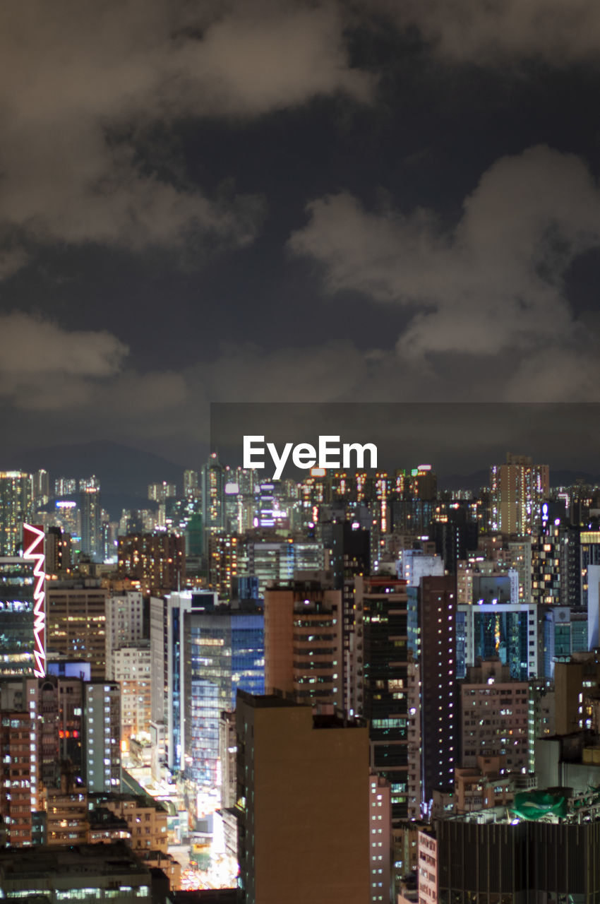 Illuminated buildings in city against sky at night