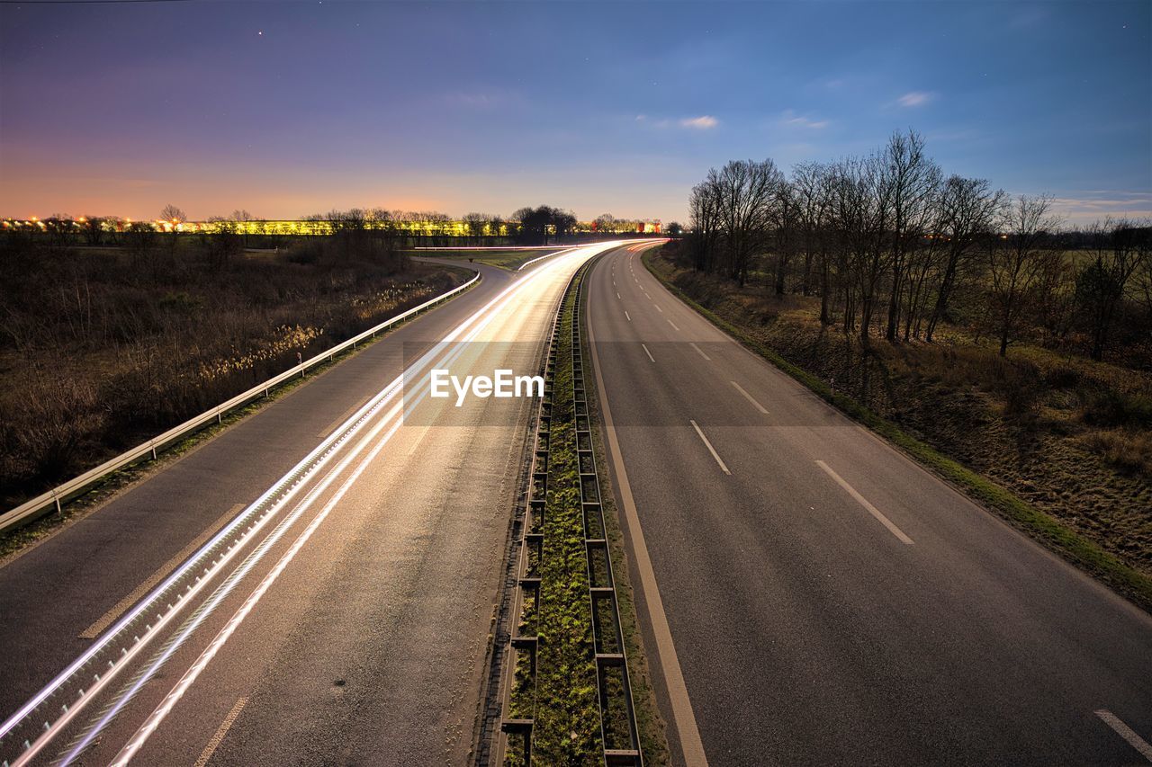 Empty road against sky at sunset