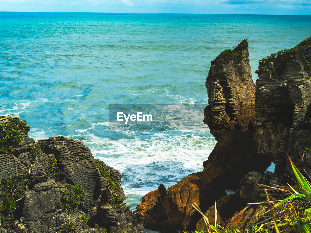 sea, water, rock, land, beach, beauty in nature, scenics - nature, ocean, coast, sky, cliff, body of water, horizon over water, shore, nature, horizon, terrain, bay, tranquility, tranquil scene, rock formation, no people, travel destinations, wave, tropics, idyllic, day, islet, travel, blue, motion, outdoors, coastline, cove, vacation, seascape, cloud, non-urban scene, tropical climate, environment, tourism, sunlight