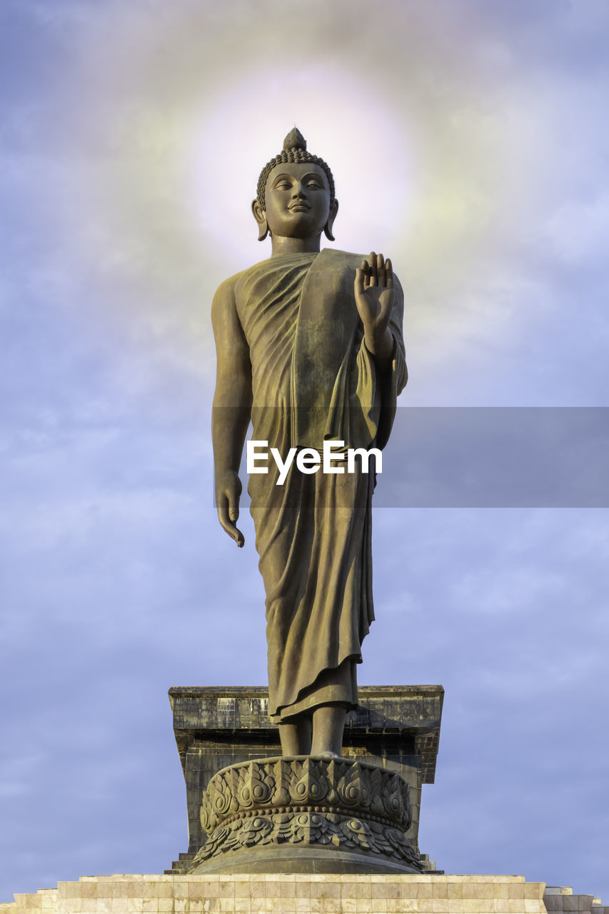 Low angle view of buddha statue against sky