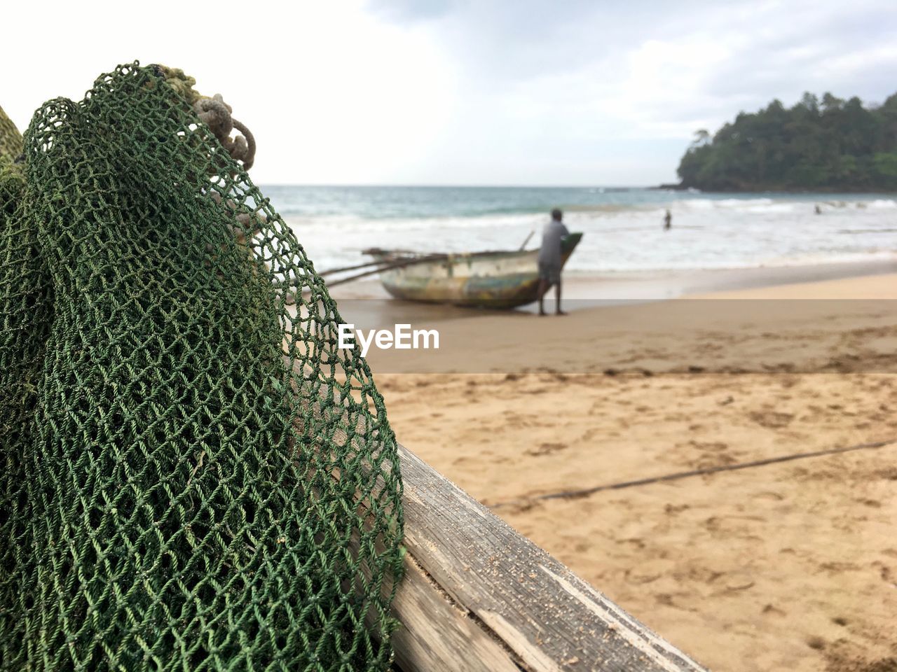 CLOSE-UP OF FISHING NET AT BEACH