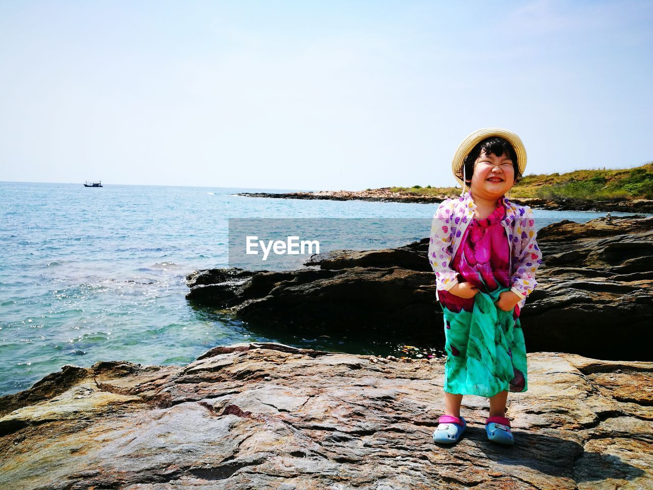 Full length of girl standing on beach against clear sky