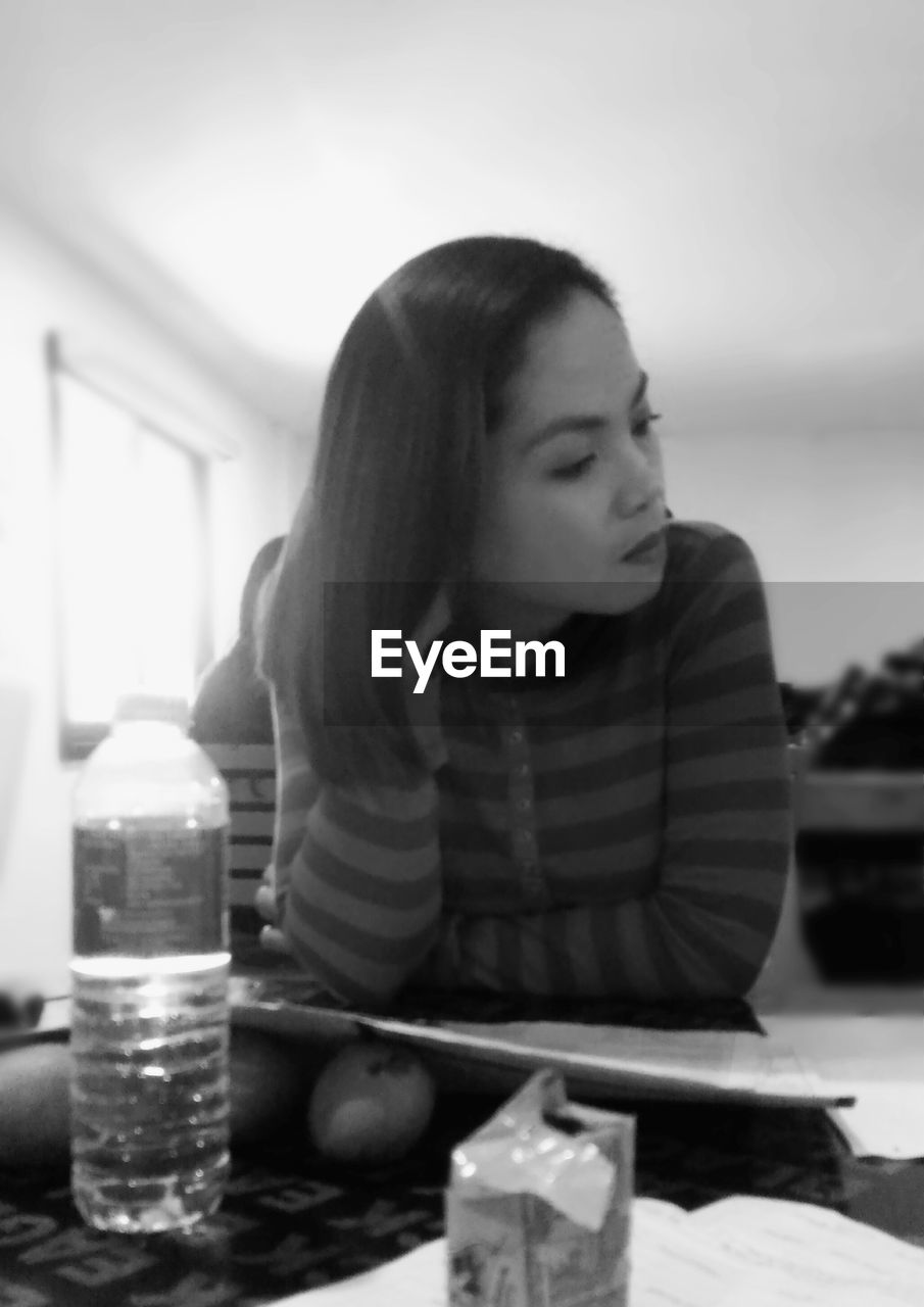 CLOSE-UP OF YOUNG WOMAN WITH DRINK IN GLASS