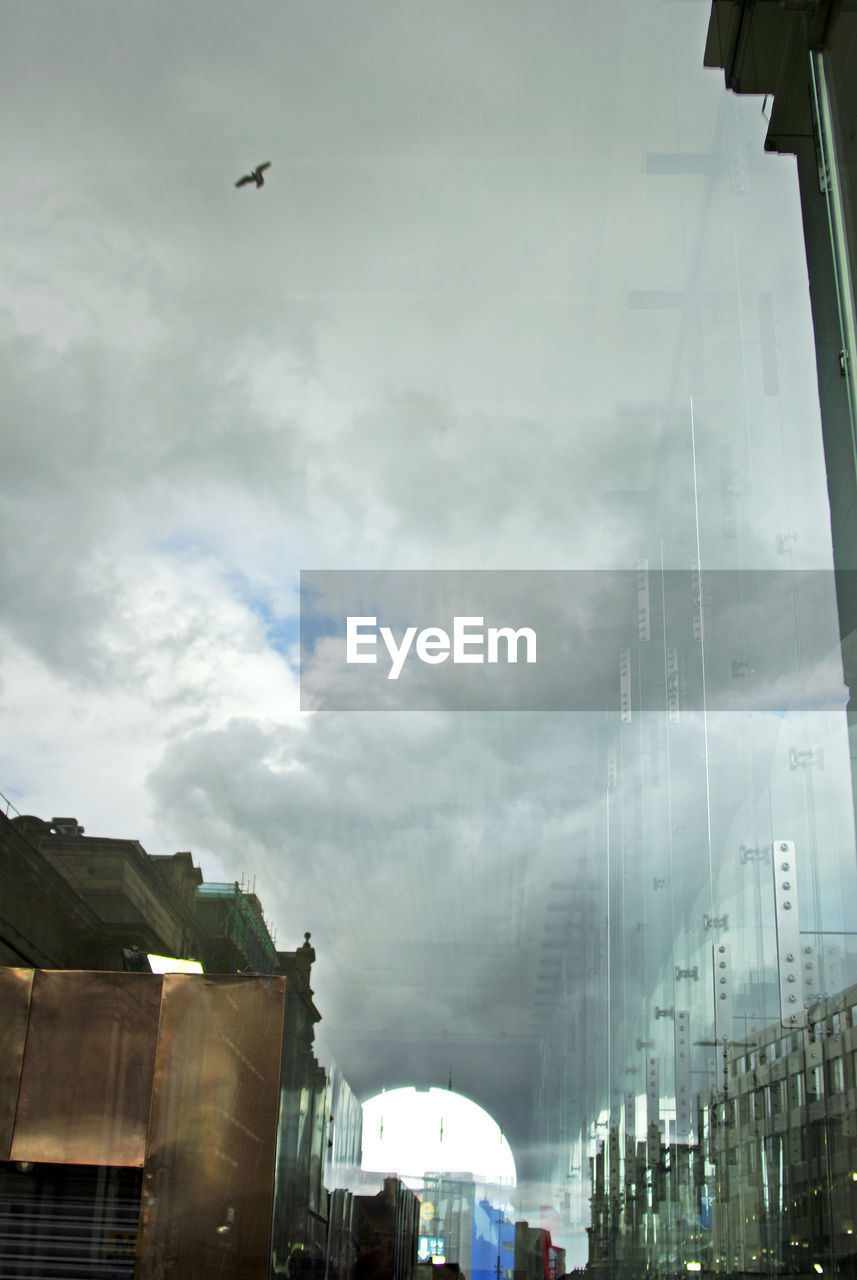 LOW ANGLE VIEW OF MODERN BUILDINGS AGAINST CLOUDY SKY