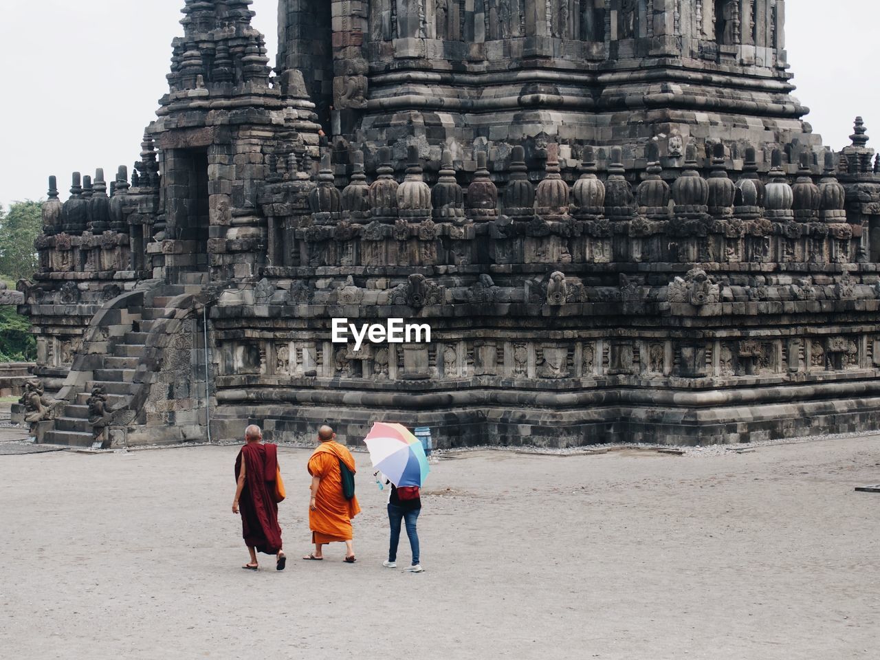 Rear view of people walking in front of temple