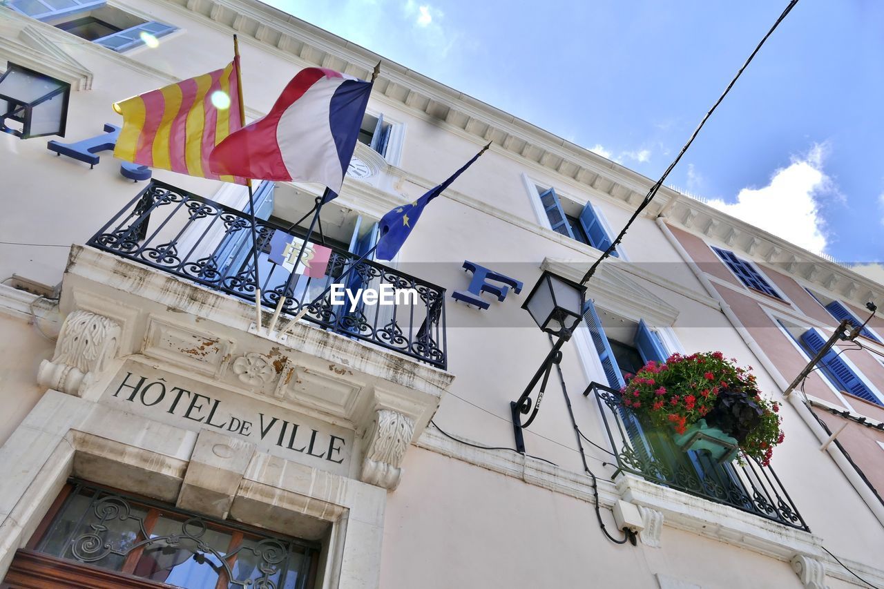 LOW ANGLE VIEW OF FLAGS HANGING ON BUILDING