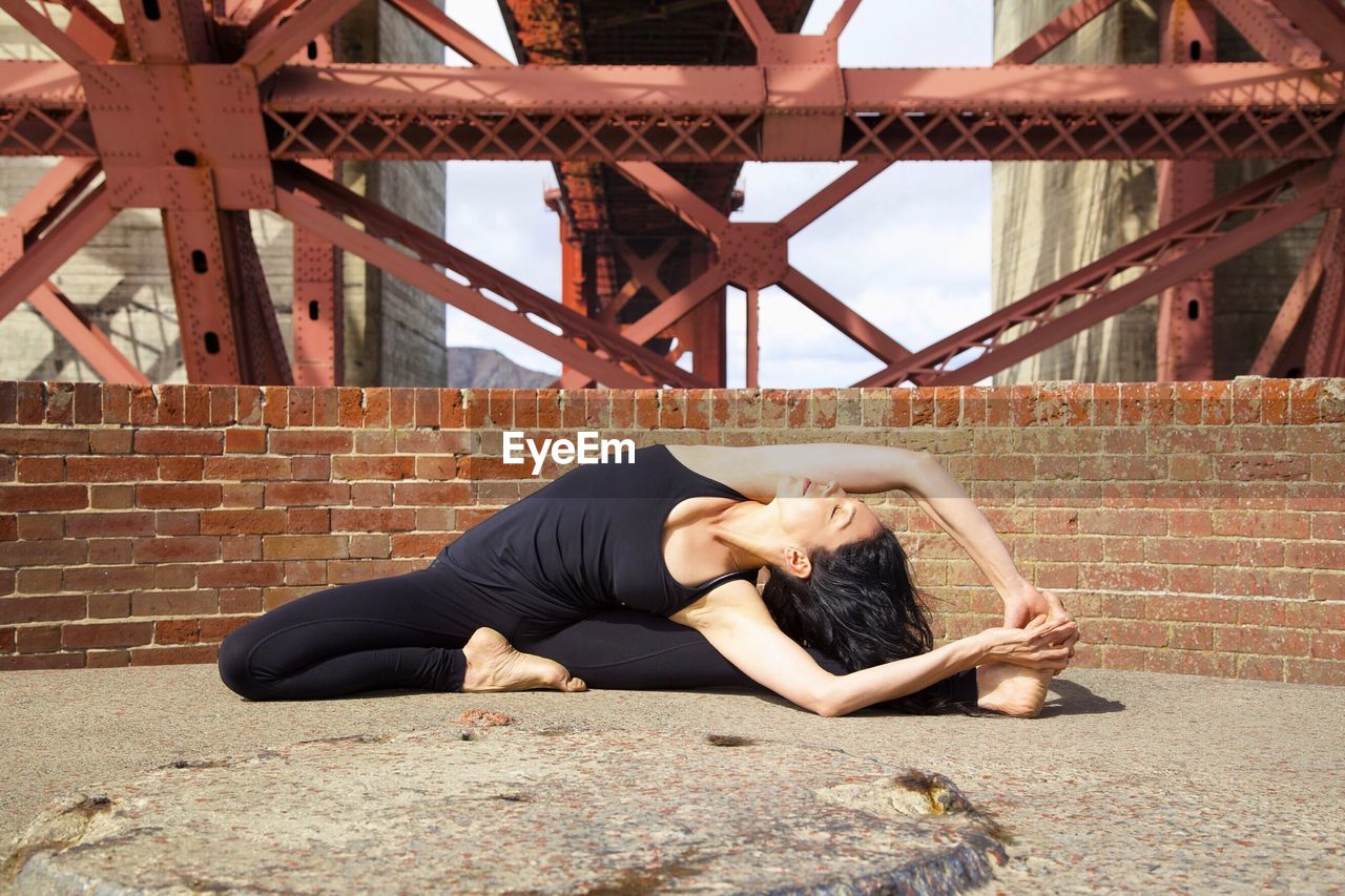 Young woman practicing yoga on golden gate bridge